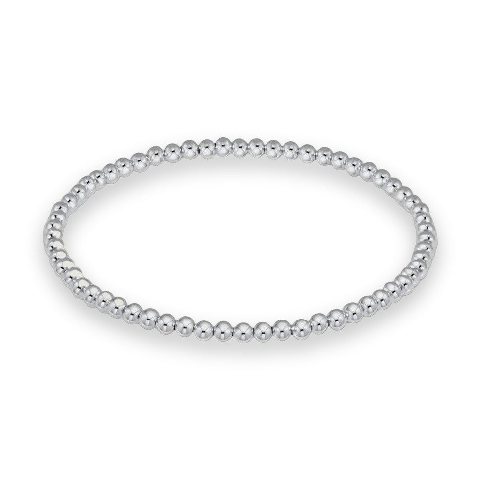 White gold Perlée beads bracelet by Van Cleef & Arpels showcased on a minimalist neutral background featuring a continuous row of high-polish spherical beads and a seamless circular silhouette