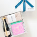 Gift basket with a bottle of champagne, bath bombs, and a card on a white background