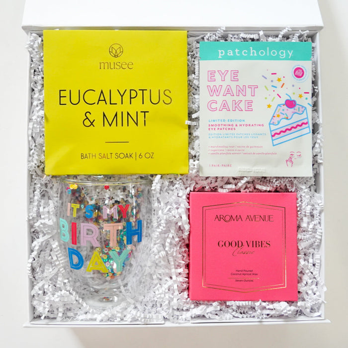 Gift box with bath salts, soap, and other items on a white background