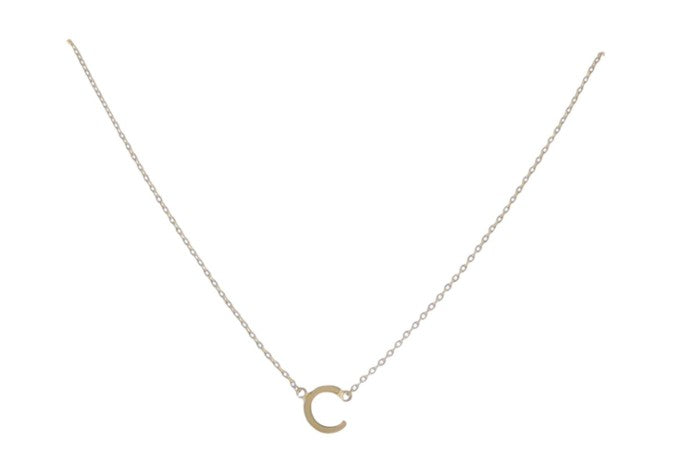 Gold-toned jewelry featuring a delicate minimalist necklace with a small polished letter C initial pendant suspended from a fine cable chain against a clean white studio background