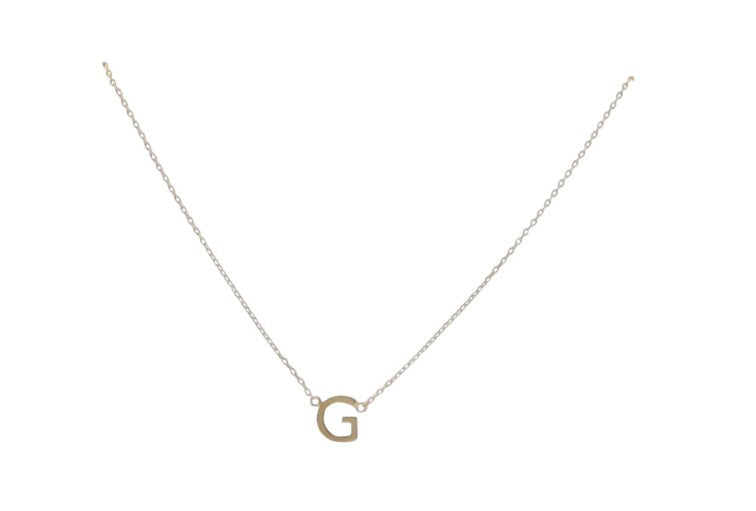 Gold jewelry necklace featuring a polished capital letter G pendant suspended from a delicate cable chain on a minimalist white background with a warm metallic sheen and fine interlocking links
