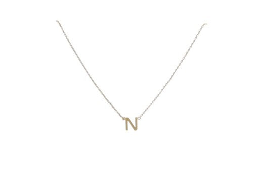 Gold jewelry featuring a minimalist initial necklace with a high-polished sans-serif capital letter N pendant and a delicate thin cable chain against a neutral white background