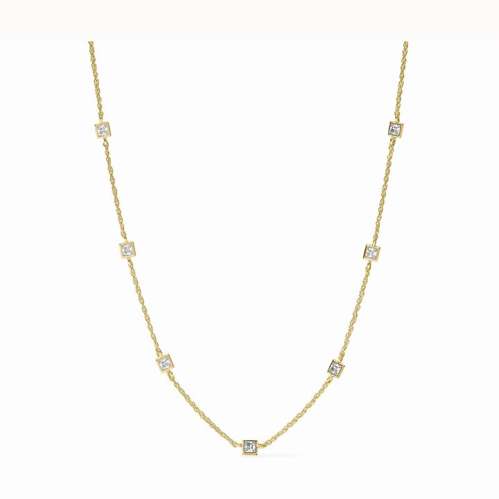 Fine jewelry yellow gold station necklace featuring seven princess-cut diamonds in square bezel settings along a delicate cable chain against a white background