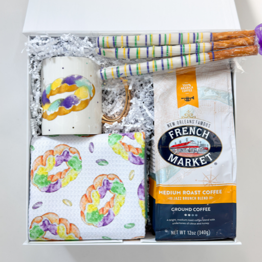 Gift set with a candle, coffee, and colorful bagels-themed items.