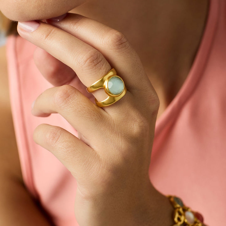 Photograph of a Julie Vos gold ring showcasing a round pale aqua chalcedony gemstone and a textured double-banded finish worn on a woman&