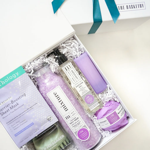 Gift set with purple and green items in a box with a teal ribbon