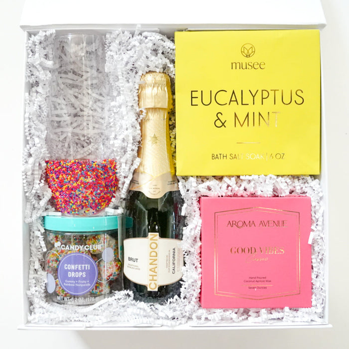 Gift set with champagne, bath salts, and other items in a box