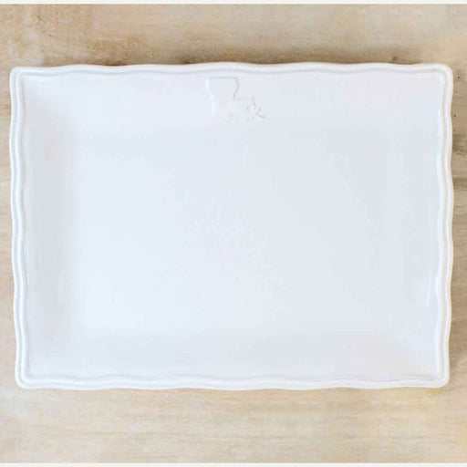Ceramic rectangular serving platter featuring an embossed map of Louisiana at the top center, resting on a neutral wooden surface with a wavy scalloped edge and a glossy white glaze