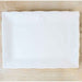 Ceramic rectangular serving platter featuring an embossed map of Louisiana at the top center, resting on a neutral wooden surface with a wavy scalloped edge and a glossy white glaze