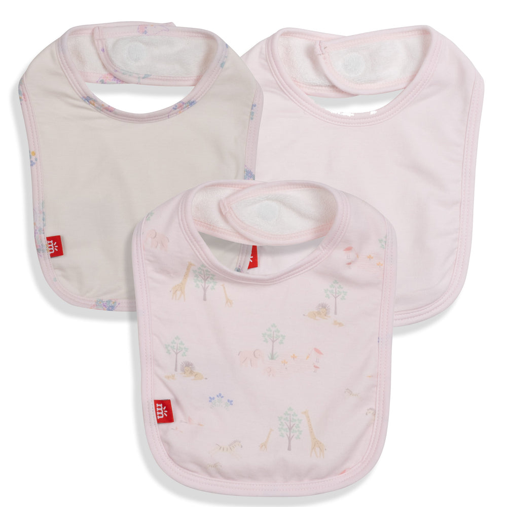 Cotton Mothercare brand baby bibs in soft pink featuring a whimsical safari animal print with giraffes and lions, hook-and-loop neck closures, and small red logo tags on a white background