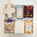Gift basket with a candle, cookies, and snacks on a white background