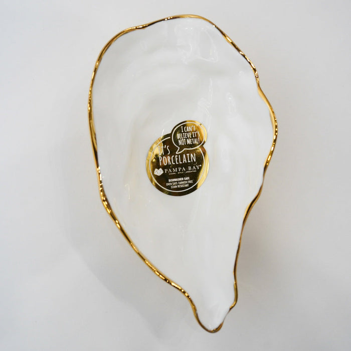 Decorative white dish with gold rim and a label on a light gray background