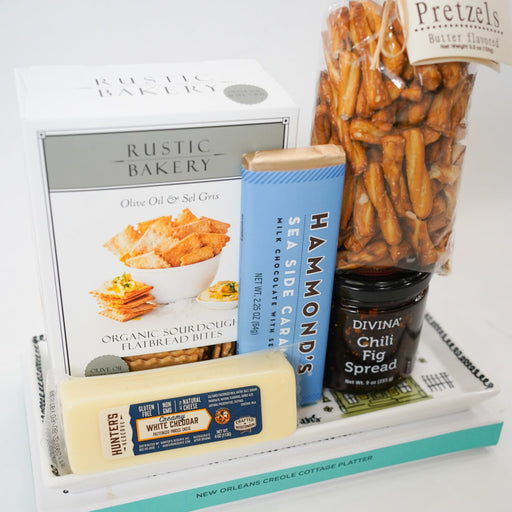 Assorted food items including pretzels, cheese, and spreads on a white surface.