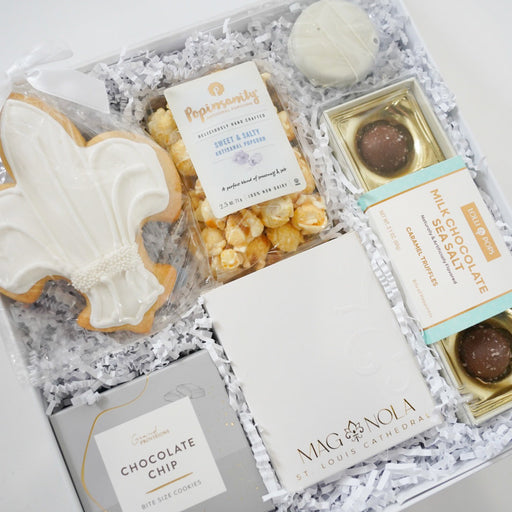 Gift box with cookies, popcorn, and chocolate truffles on a white background