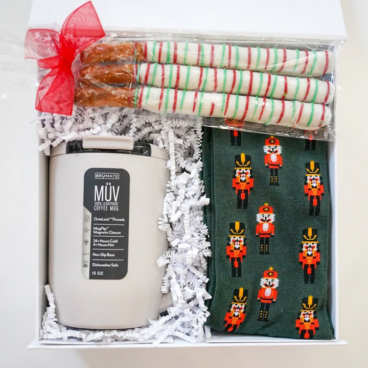 Gift set with a candle, candy canes, and nutcracker-themed cards in a box.