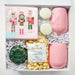 Gift box with pink soaps, popcorn, and decorative items on a white background