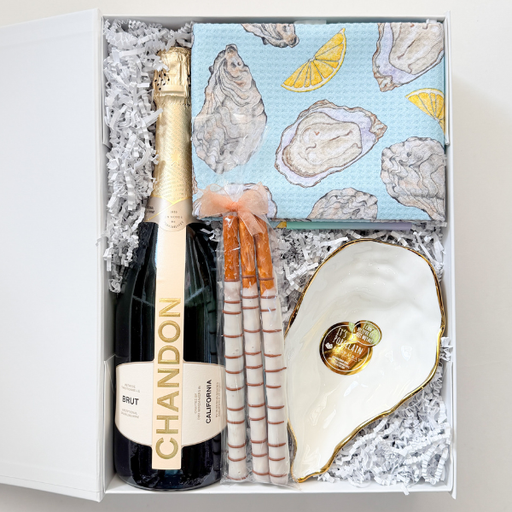 Gift set with Chandon champagne, oyster shells, and a shell-shaped plate in a decorative box.