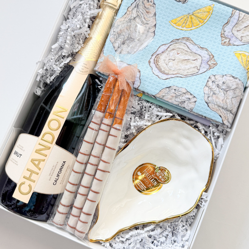 Gift set with Chandon sparkling wine, oyster shells, and a card in a decorative box.