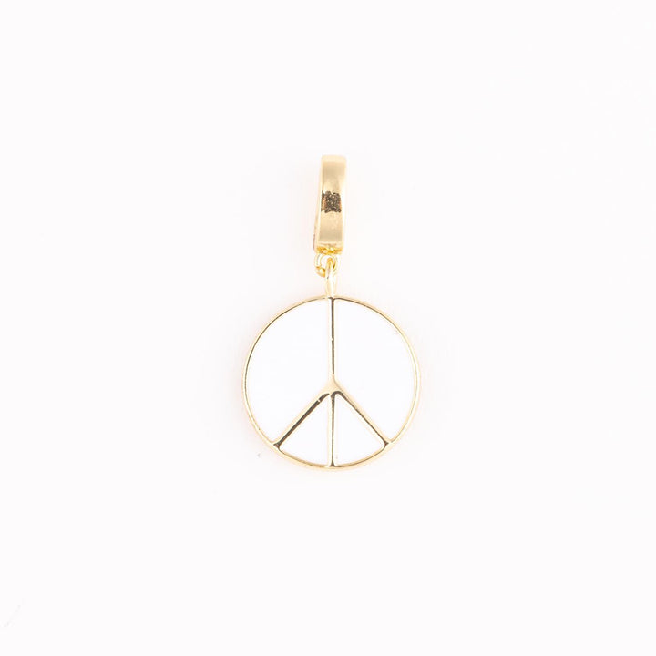 Gold and enamel jewelry pendant featuring a centered peace sign symbol with high-polish metallic edges, a smooth white inlay, and a reflective rectangular bail