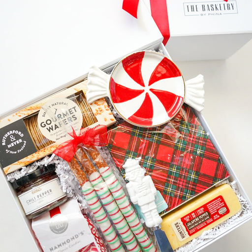 Gift basket with candy, cookies, and a red ribbon on a white background