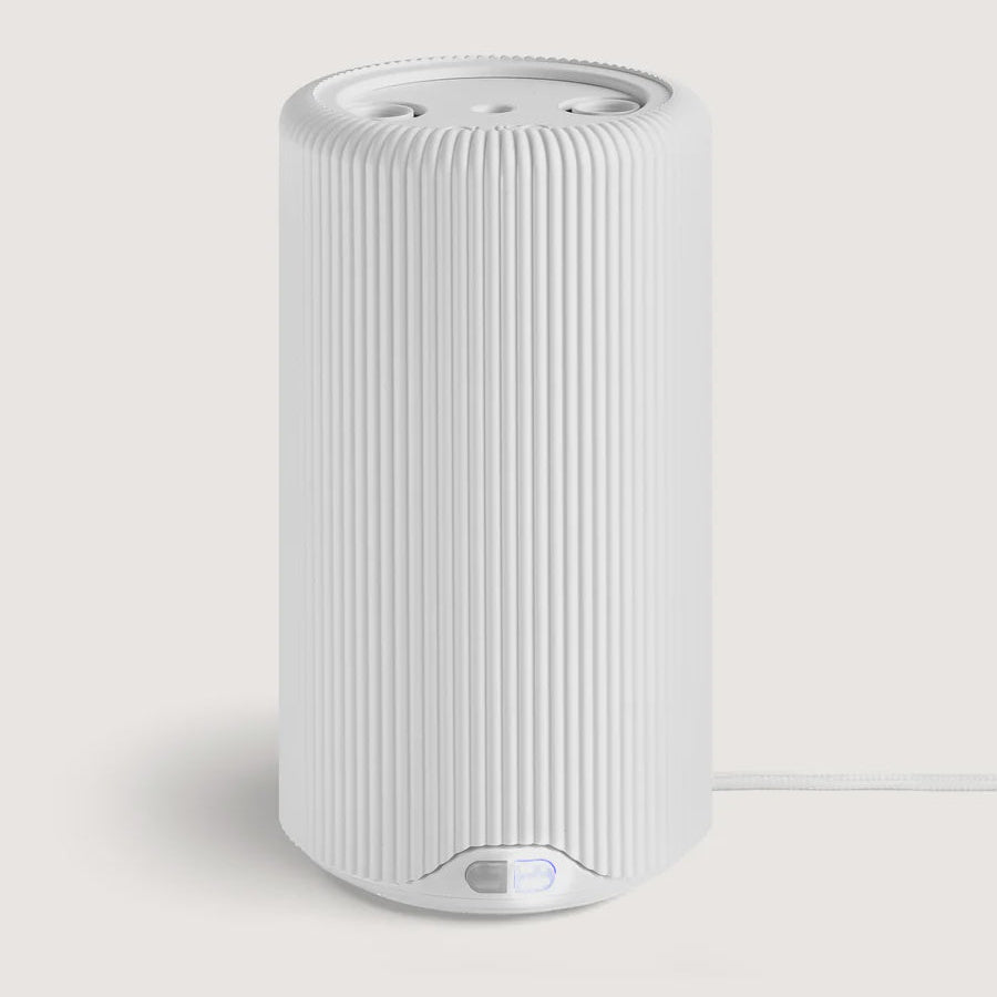Tall white ribbed cylindrical Pura fragrance diffuser with a power cord
