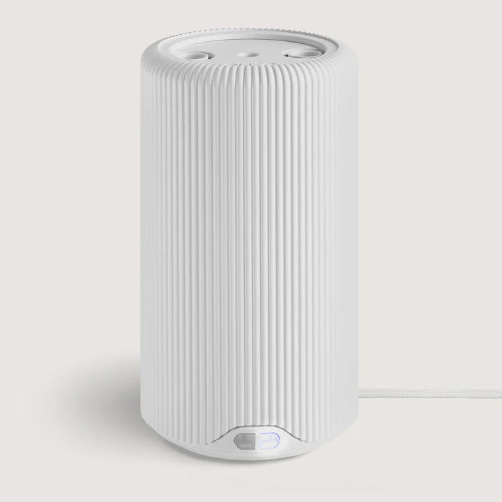 Tall white ribbed cylindrical Pura fragrance diffuser with a power cord