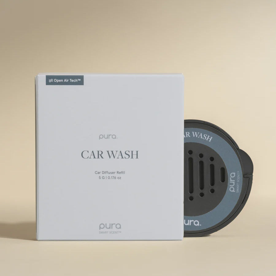 Studio product photograph by Pura featuring a Car Wash diffuser refill on a neutral background with a minimalist white box and a charcoal grey circular scent disc showing perforated holes and the Open Air Tech logo