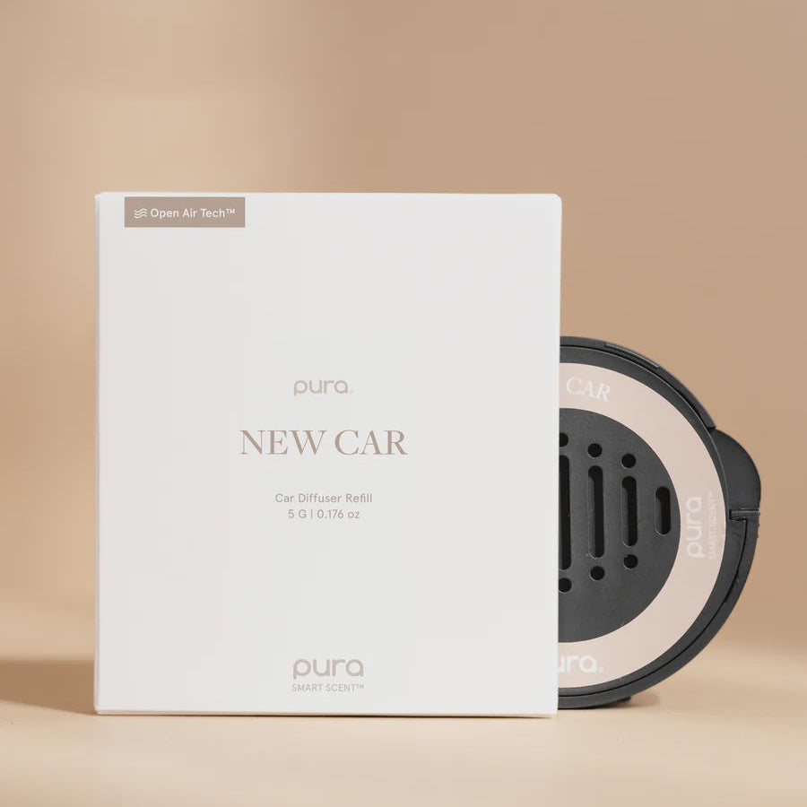 Product photograph by Pura of a New Car scent car diffuser refill and circular disc on a tan background featuring minimalist white packaging, the Open Air Tech logo, and a black cartridge with ventilation holes