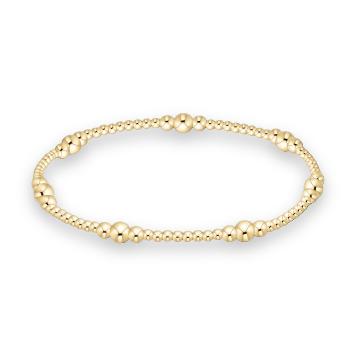 Yellow gold beaded bracelet featuring graduated polished spheres and brilliant mirrored highlights against a solid black background