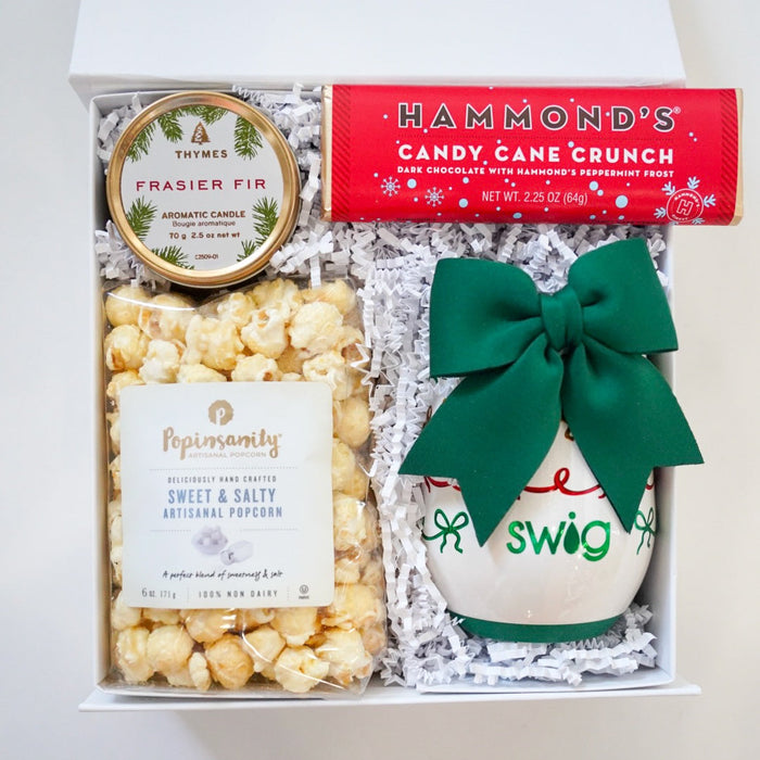 Gift box with popcorn, candy, and a mug on a white background