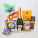 Gift basket with champagne, snacks, and Mardi Gras-themed items on a white background