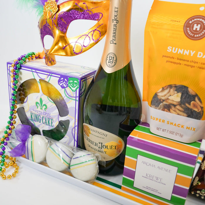 Mardi Gras-themed gift tray with champagne, snacks, and a mask on a white background