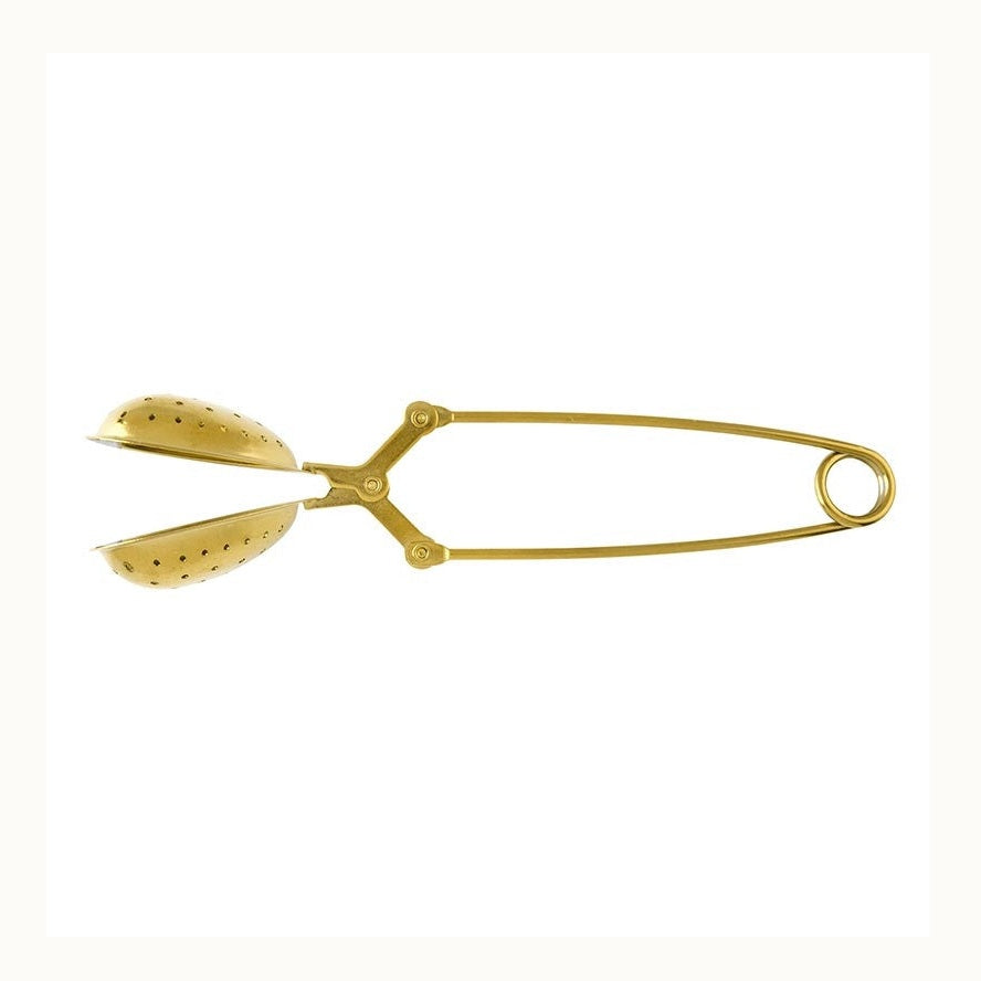 Brass metal tea infuser tongs featuring perforated oval baskets and a long spring-loaded handle with a circular loop end against a white background
