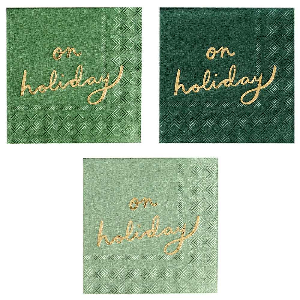 Three cocktail napkins in shades of green with on holiday in gold foil script