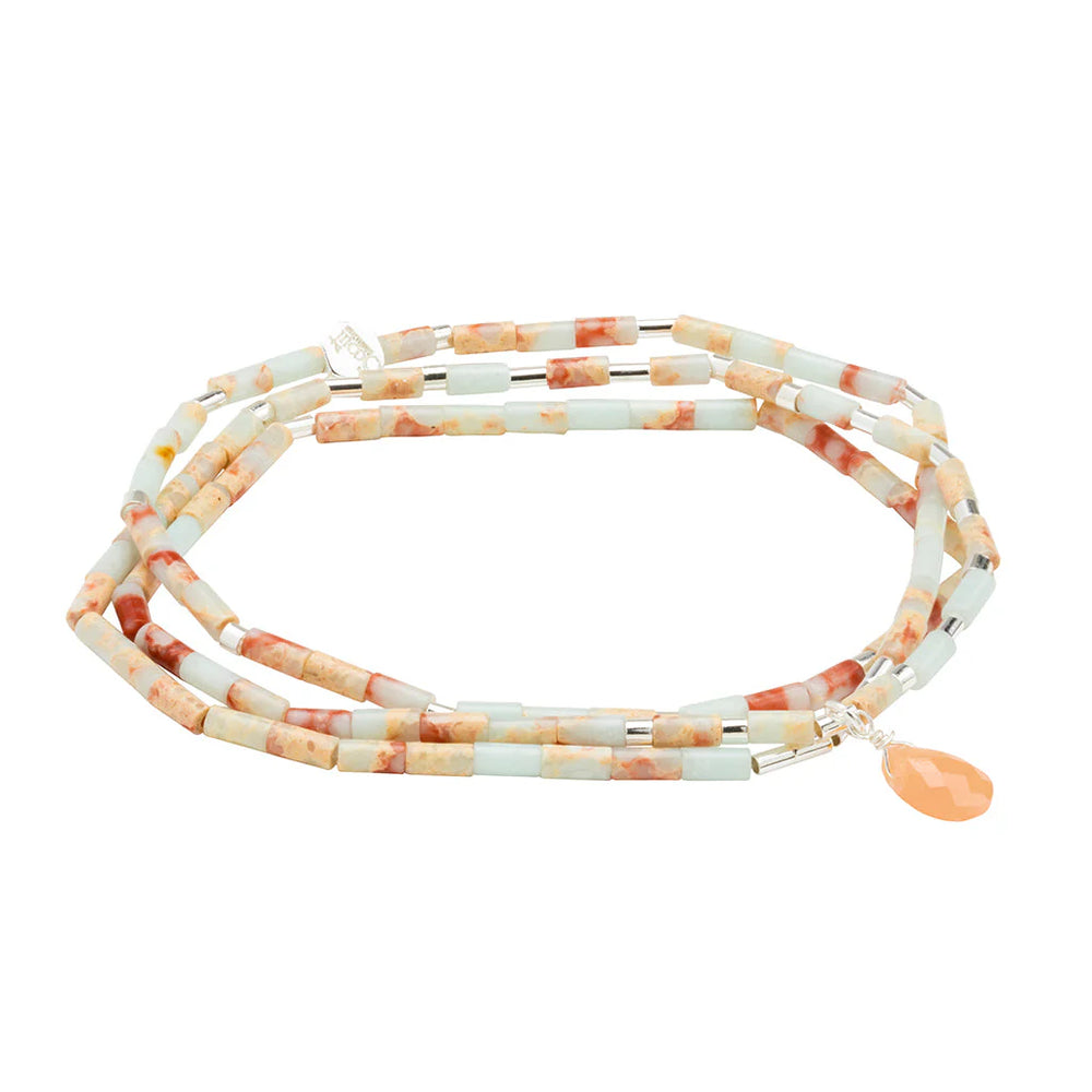 Beaded jewelry by Scout Curated Wear features a multi-wrap bracelet on a white background showcasing marbled terracotta and mint cylindrical beads accented with a faceted peach teardrop charm and a silver logo tag