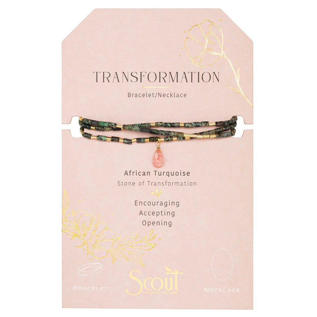 Jewelry by Scout Curated Wear featuring an African Turquoise beaded bracelet and necklace on a blush pink card labeled Transformation with mottled green stones, gold spacers, and a faceted pink teardrop pendant