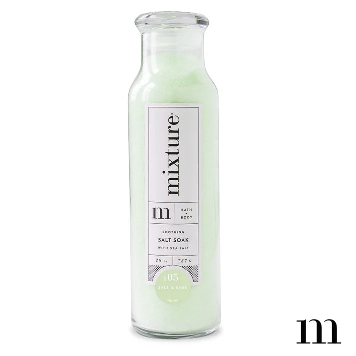 Tall glass bottle of Mixture soothing salt soak with pale green salt