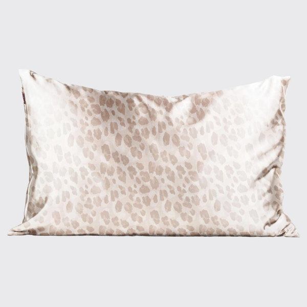 Silk satin pillowcase featuring a muted leopard print in blush pink and taupe tones centered on a neutral studio background with a soft luminous sheen and delicate fabric ripples