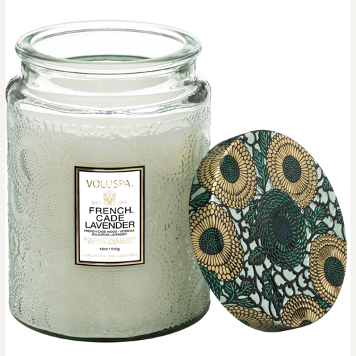 Scented glass jar candle by Voluspa featuring the French Cade Lavender fragrance from the Japonica Collection on a white background, showcasing an intricate embossed floral texture and a decorative lid with metallic gold and teal botanical patterns