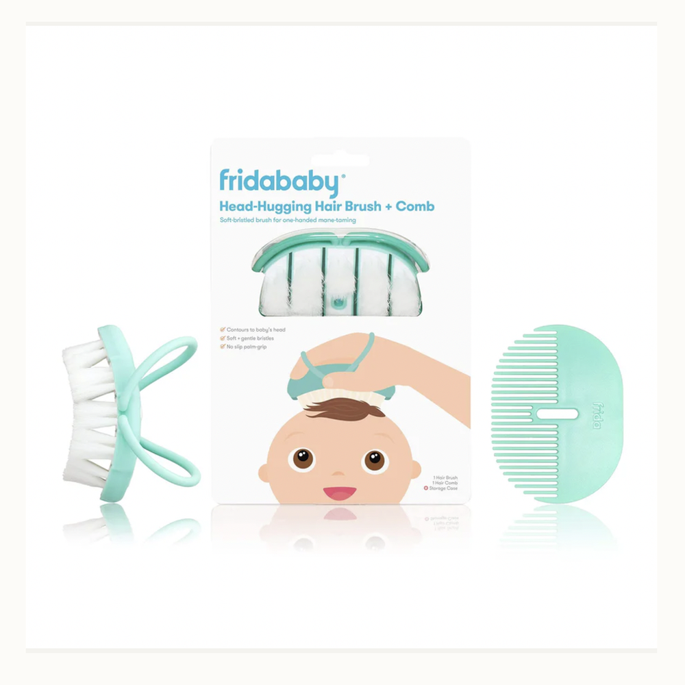 Product photography by Fridababy of a mint green Head-Hugging Hair Brush and Comb set featuring flexible palm-grip loops, soft white bristles, and a central packaging card displaying the brand logo and a baby illustration