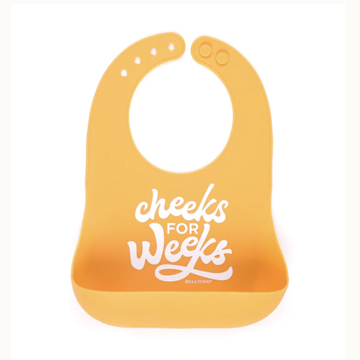 Silicone baby bib by Bella Tunno featuring the white script phrase cheeks FOR weeks on a mustard yellow background with an adjustable neck strap and a deep crumb catcher pocket centered on a white background
