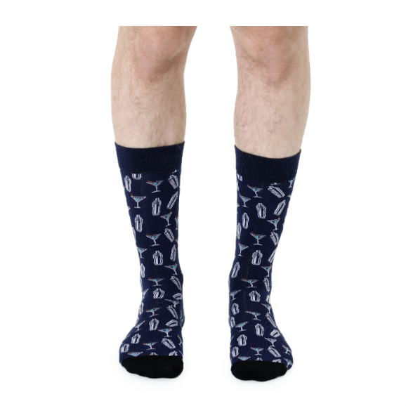 Digital photograph of navy blue crew socks worn on a person's lower legs against a white background featuring a recurring pattern of white cocktail shakers and martini glasses with small green olives and black-tipped toes