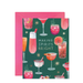 Watercolor illustration by Rifle Paper Co. of a festive holiday greeting card featuring various colorful cocktails garnished with rosemary sprigs and candy canes on a dark green background with gold stars and a bright pink envelope