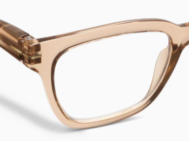 Close-up of a translucent tan glasses frame corner with a metal hinge accent