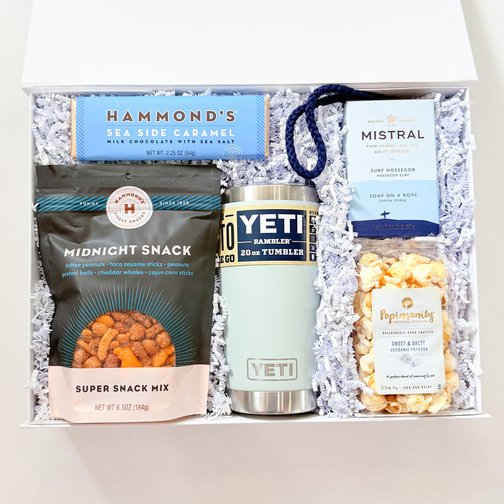 Gift box with snacks and a Yeti cooler on a white background
