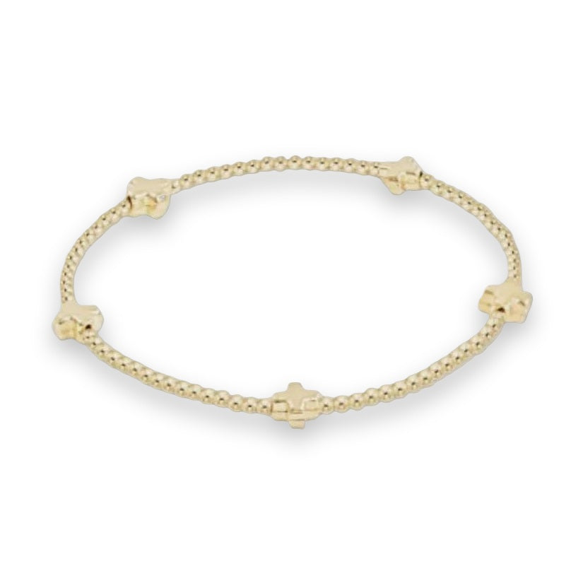 Gold-toned beaded jewelry bracelet by Erimish displayed on a light gray studio background featuring five chunky puffy cross charms interspersed with small reflective spherical beads and a polished metallic finish