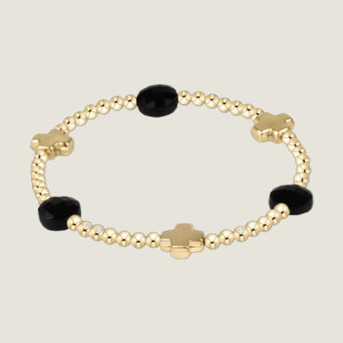 Gold beaded bracelet by an unknown designer featuring three polished gold cross charms and three faceted black gemstone beads interspersed with reflective spherical metallic spacers on a white background