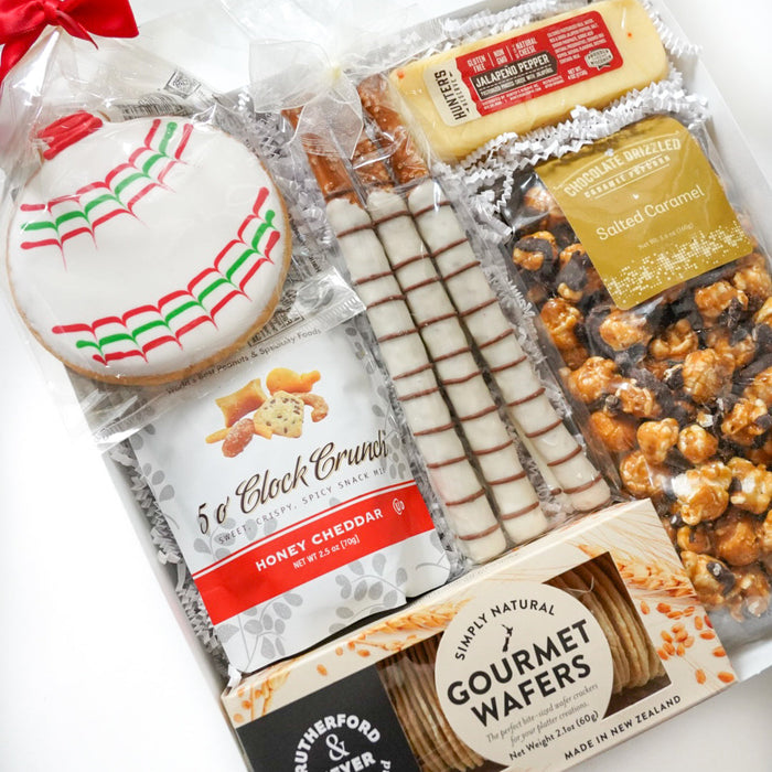Assorted gourmet snacks including cookies, wafers, and popcorn on a white background