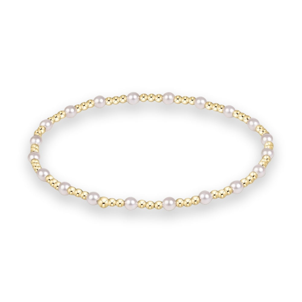 Gold and pearl beaded jewelry bracelet featuring an alternating pattern of small polished gold spheres and lustrous white pearls centered on a minimalist white studio background