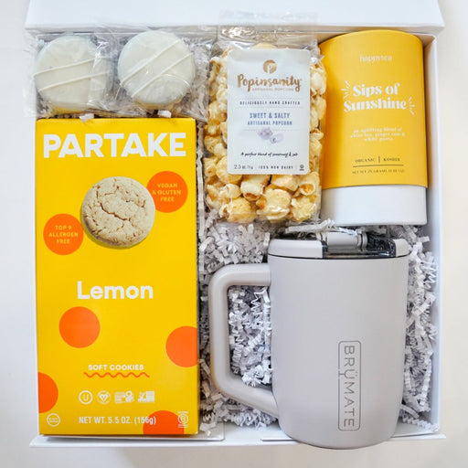 Gift box with Partake lemon product, mug, and other items on a white background